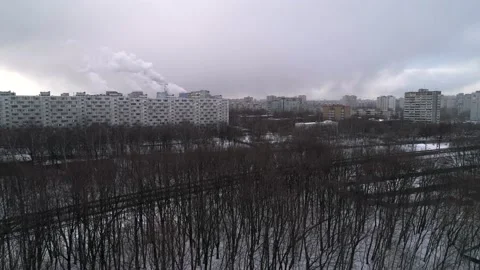 Flight over a black winter forest towards concrete high-rise buildings Stock Footage 146955203