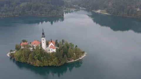 Flight over of Bled Island (Blejski otok) with pilgrimage church Stock Footage 123701203