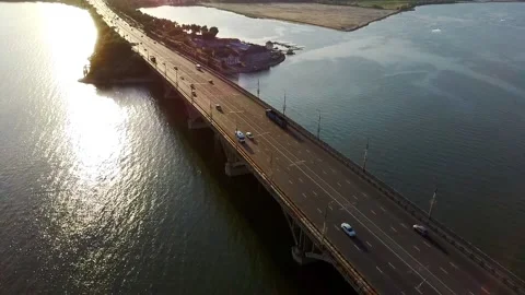 Flight over the bridge over which the car goes at sunset Video stock 134569919