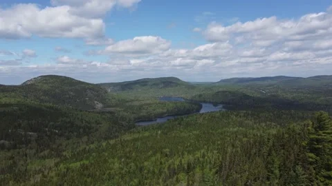 Flight Over a Bright Green Mountain Forest and Lake - Sept Chutes Stock Footage 158177376