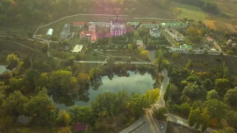 Flight over a christian monastery surrounded by autumn forest at sunset. Kurky Stock Footage 136647905