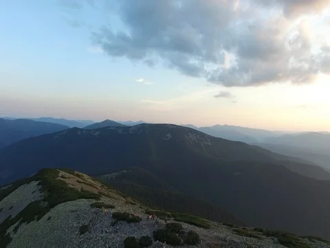 Flight over company of friends who standing on the mountain range Stock Footage