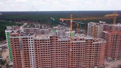 Flight over the construction of a high-rise building made of bricks with cranes Stock Footage 126701066