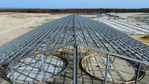 Flight over construction of a large metal structure in an agricultural area Stock Footage 306300626