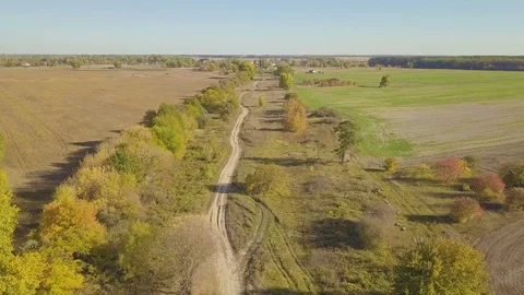 Flight over dirt road through farm fields, aerial video 動画素材 96312736
