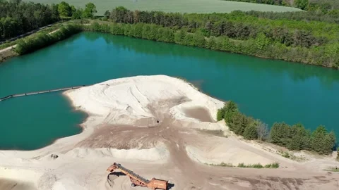Flight over the edge of sand mining with a groundwater lake Stock Footage 130958272