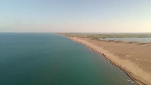 Flight over expansive plains and along a long, scenic coastal strip Stock Footage 261032769