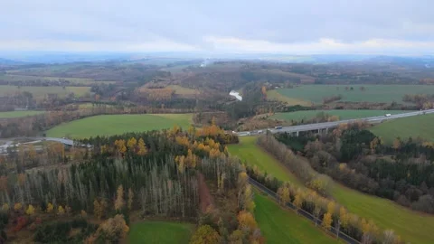 Flight over a field and forest next to a highway. Stock Footage 294386076