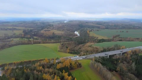 Flight over a field and forest next to a highway. Stock Footage 294386086