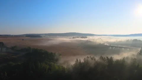 Flight over a field and forest in the morning fog near a railway viaduct. Stock Footage 294386924