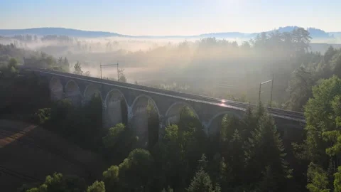 Flight over a field and forest in the morning fog near a railway viaduct. Stock Footage 294388271