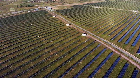 Flight over a field of solar panels near a large metropolis Stock Footage 135380960