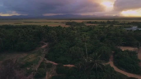 Flight over fields against backdrop of softly pink-purple sunset mountains Stock Footage 273533760