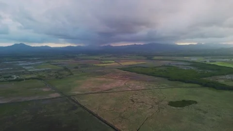 Flight over fields against backdrop of softly pink-purple sunset mountains Stock Footage 273729475
