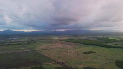 Flight over fields against backdrop of softly pink-purple sunset mountains Stock Footage 273729585