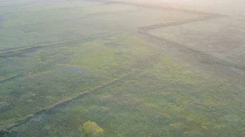 Flight over fields with a sunset in the background Stockbeeldmateriaal 137854041