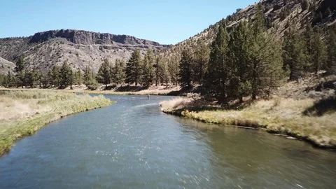 Flight over Flyfisherman at remote high desert flyfishing stream canyon Stock Footage 95875243