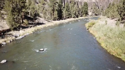 Flight over Flyfisherman at remote high desert flyfishing stream canyon Stock Footage 95876746
