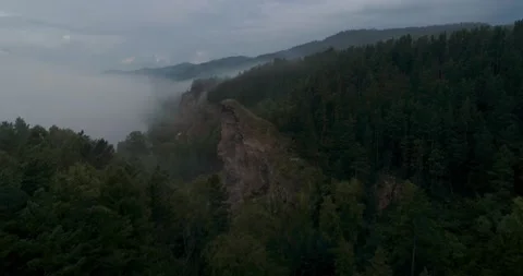Flight over forest shore with cliff in fog Stock Footage 167646094