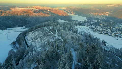 Flight over forest in winter towards snow covered valley and village in winter Stock Footage 231223694