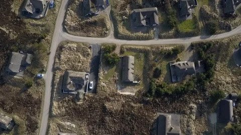 Flight over grass covered dunes and holiday houses at Henne Strand Stock Footage 87256768