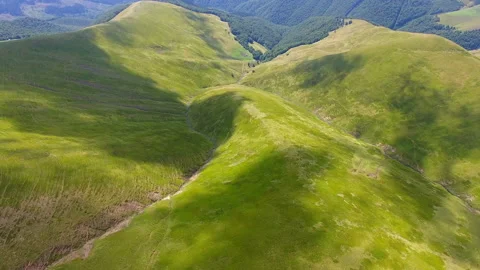 Flight over a green grassy mountains Stock Footage 78725419
