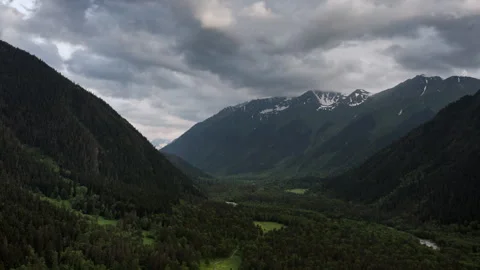 Flight over green valley of trees. Aerial view of valley in cloudy weather. Stock Footage 283217683
