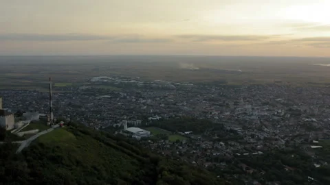 Flight over a hill with a town under it and a scenic sunset panorama Stockbeeldmateriaal 138023520
