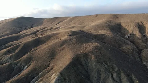 Flight over the hills in the rays of sunset Stock Footage 105679984