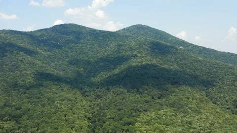 Flight over a huge mountain terrain covered by thick woods Stockbeeldmateriaal 138375606