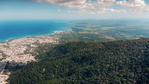 Flight over the island beach line,  distant port city and the blue ocean Stock Footage 101758904