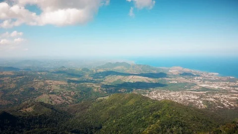 Flight over the island hills,  distant port city and the blue ocean Stock Footage 101757758