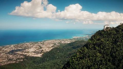 Flight over the island mountain, beach line, distant port city Stock Footage 101756345