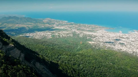 Flight over the island mountain, beach line, distant seaport and the blue ocean Stock Footage 101759385
