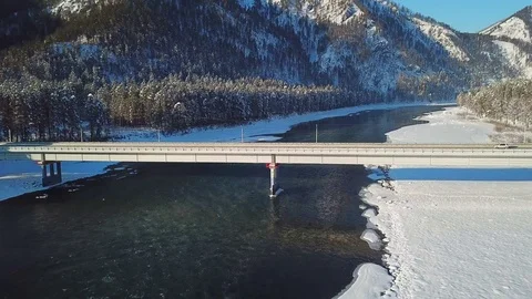 Flight over the Katun river covered with ice and snow with an automobile brid Stock Footage 125014255