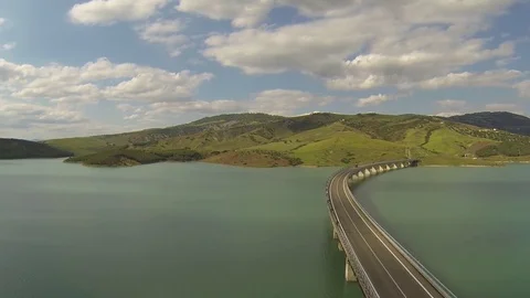 Flight over the lake bridge with background mountains on a cloudy day Stock Footage 72167108