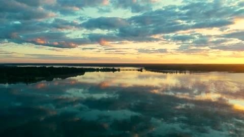 Flight over lake at dawn with cloudy blue sky reflecting. Stock Footage 137983523
