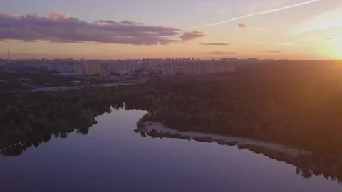Flight over the lake during sunset overlooking the city with beautiful clouds Stock Footage 143211260