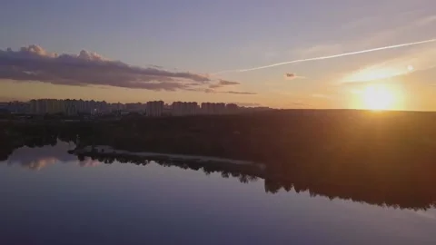 Flight over the lake during sunset overlooking the city with beautiful clouds Stock Footage 143314403