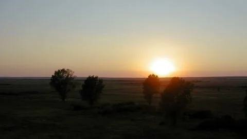 Flight over a large field with a sunset in the background Stock Footage 137854219