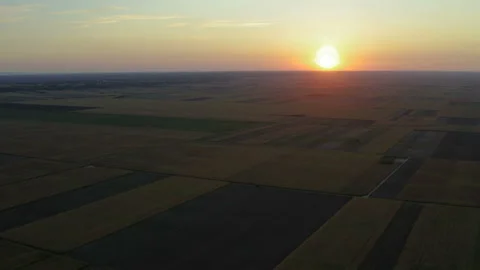 Flight over a large field with a sunset panorama filled with wild colors Stockbeeldmateriaal 138258741