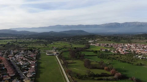 Flight over meadows and a mountain-bottomed village Stock Footage 126238514