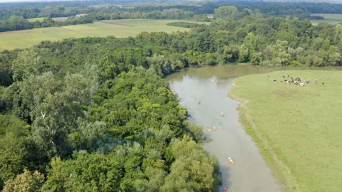 Flight over meanders of a small river with a kayak race on a sunny day Stockbeeldmateriaal 137970167