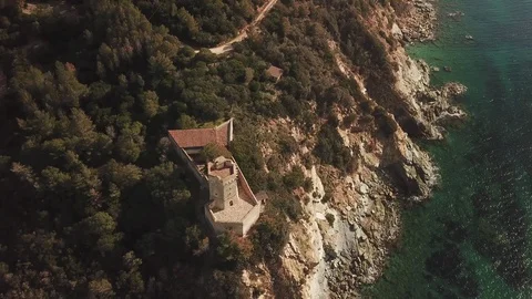 Flight over a medieval tower overlooking a cliff on a rocky coast Stock Footage 101899873