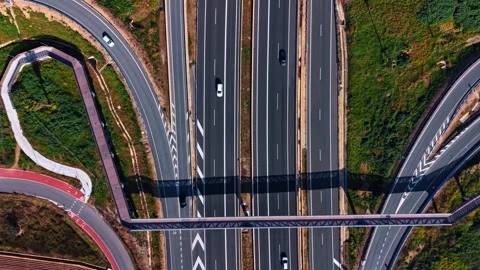 Flight over the modern parallel motorways. A footbridge and trestle are over the Vídeo Stock 332678941