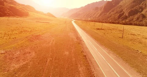 Flight over mountain asphalt highway road and meadow Stock Footage 119890903