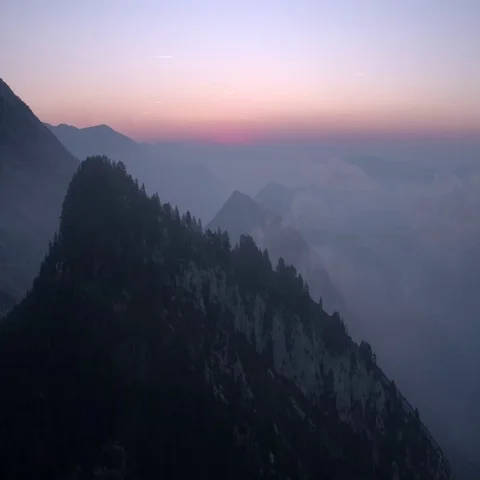 Flight over mountain peak into pink sunrise Stock Footage 69503055