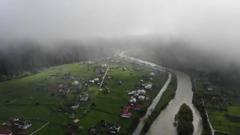Flight over  mountain village with forest in sunrise through the mist  . Stock Footage 108294692