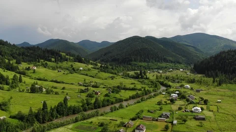 Flight over  mountain village with forests, fields and river. Video stock 117368087