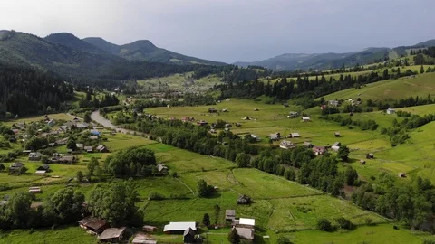 Flight over  mountain village with forests, fields and river. Stock Footage 117368486